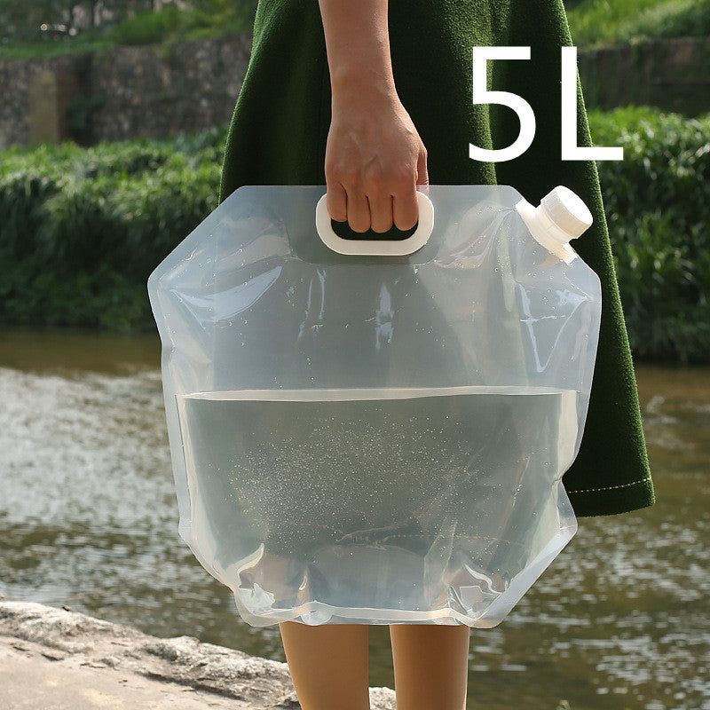 SoraCool Foldable Water Carrier — clear water carrier held by its handle outdoors with a five-liter label
