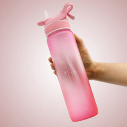 SoraCool Time-Marker Mist Water Bottle — pink bottle held in a hand on a pale pink background